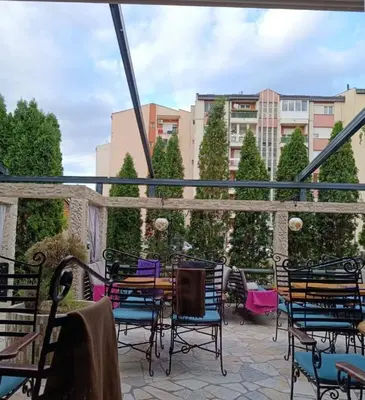 a patio with chairs and a table on a balcony at Modern Spacious ViS Raska Apartment! 5min Cafes in Raška
