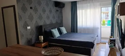 a bedroom with a bed with blue sheets and a window at Apartman Seka in Vrnjačka Banja