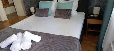 a bedroom with a large bed with white sheets and pillows at Apartman Seka in Vrnjačka Banja