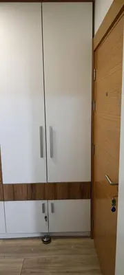 a kitchen with white cabinets and a wooden door at Apartman Seka in Vrnjačka Banja