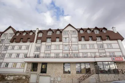 a large white building with a brown roof at Studio Kruna Kopaonik in Kopaonik