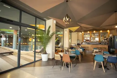 a restaurant with tables and chairs and a pool at Studio Kruna Kopaonik in Kopaonik