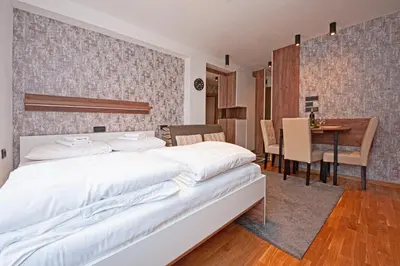 a bedroom with a large white bed and a table at Studio Kruna Kopaonik in Kopaonik