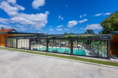 an image of a house with a pool and glass extension at Apartman Vrnjacka Banja in Vrnjačka Banja