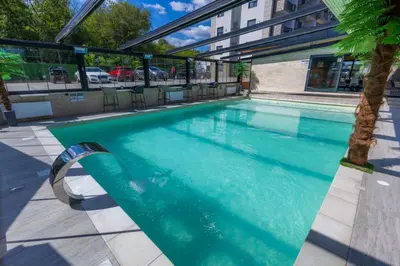 a swimming pool with blue water in a building at Apartman Vrnjacka Banja in Vrnjačka Banja