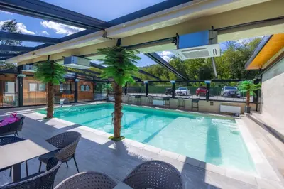 a swimming pool with a table and chairs at Apartman Vrnjacka Banja in Vrnjačka Banja