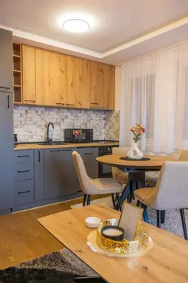 a kitchen with a table and some chairs and a table at Apartman Vrnjacka Banja in Vrnjačka Banja