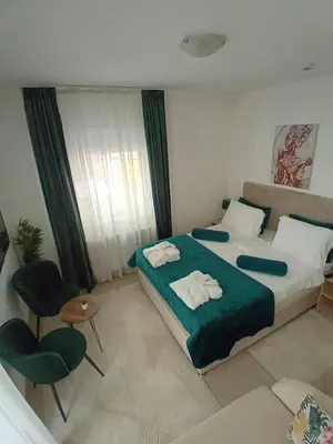 a bedroom with a large bed with two towels on it at Wing Apartman Jagodina in Jagodina