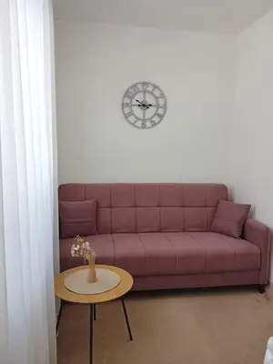 a living room with a purple couch and a table at Wing Apartman Jagodina in Jagodina