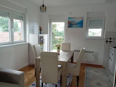 a kitchen and dining room with a table and chairs at Studio apartman in Vrnjačka Banja