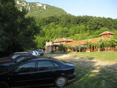a black car parked in front of a house at Apartments Izvor Lisine in Strmosten