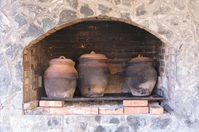 three clay vases sitting in a brick oven at Apartments Izvor Lisine in Strmosten