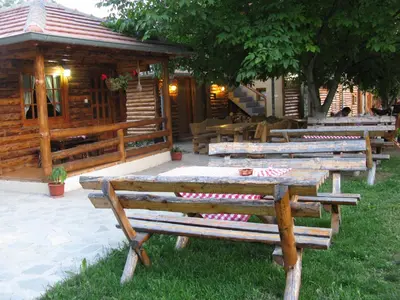 a group of picnic tables in front of a cabin at Apartments Izvor Lisine in Strmosten