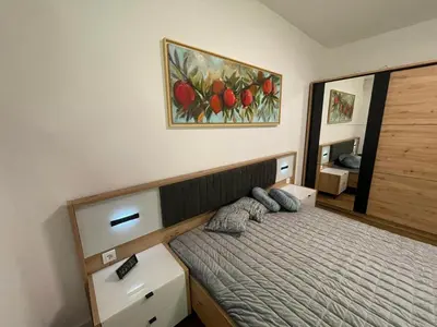 a bedroom with a bed and a painting on the wall at Skyline Lux Apartment by Planet Residence in Niš