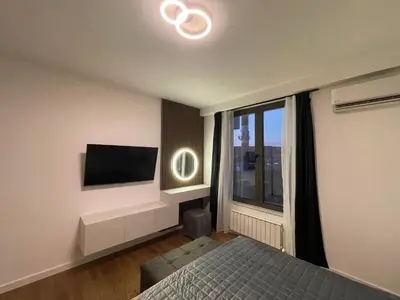 a bedroom with a bed and a flat screen tv at Skyline Lux Apartment by Planet Residence in Niš