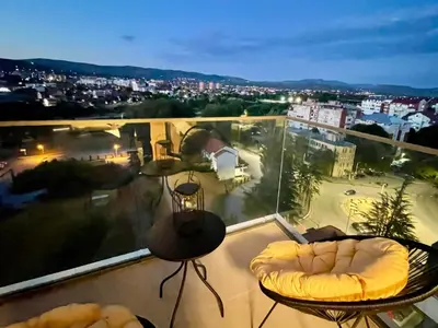 a balcony with a view of a city at night at Skyline Lux Apartment by Planet Residence in Niš