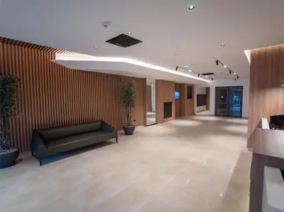 a lobby with a black couch in a building at Skyline Lux Apartment by Planet Residence in Niš