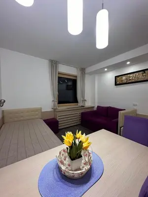 a room with a table with a bowl of flowers on it at Angela 103 in Kopaonik