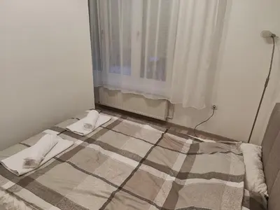 a bed in a room with a window at Konstantin Apartment in Niš