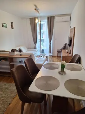 a living room with a bed and a table and chairs at Apartman Eva in Vrnjačka Banja
