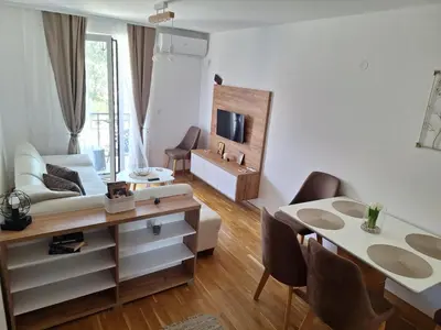 a living room with a table and a dining room at Apartman Eva in Vrnjačka Banja