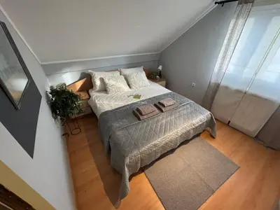 a small bedroom with a bed and a window at Prostran moderan apartman110 kvadrata u centru- 2 spavaće sobe, parking u dvoristu in Jagodina