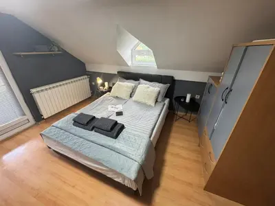 a bedroom with a large bed and a window at Prostran moderan apartman110 kvadrata u centru- 2 spavaće sobe, parking u dvoristu in Jagodina
