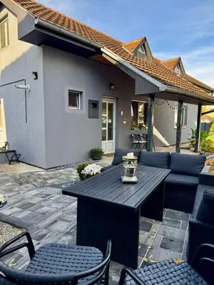 a patio with a table and chairs and a house at Prostran moderan apartman110 kvadrata u centru- 2 spavaće sobe, parking u dvoristu in Jagodina