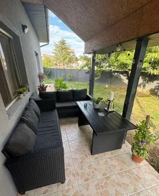 a patio with a couch and a table on a porch at Prostran moderan apartman110 kvadrata u centru- 2 spavaće sobe, parking u dvoristu in Jagodina