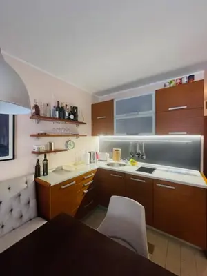 a kitchen with brown cabinets and a table and chairs at Cozy Bianca Studio in Kopaonik