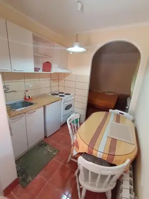 a small kitchen with a table and chairs in it at Smeštaj Golubica 5 in Soko Banja