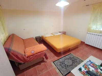 a small room with a bed and a table at Smeštaj Golubica 5 in Soko Banja