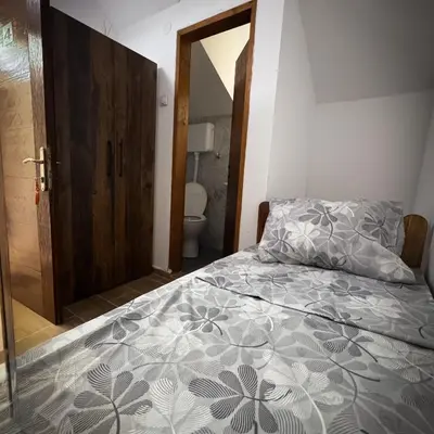 a bedroom with a bed and a bathroom with a toilet at Apartmani Jovca in Aleksinac