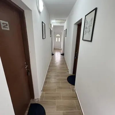 a hallway with white walls and tile floors and a hallway with doors at Apartmani Jovca in Aleksinac