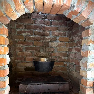 a brick oven with a bucket in a brick wall at Apartmani Jovca in Aleksinac