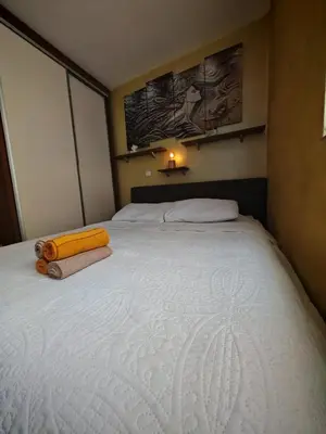 a bedroom with a large white bed with towels on it at Magic Apartman Kop - Kraljevi Cardaci in Kopaonik