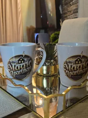 two coffee mugs sitting on top of a glass table at Magic Apartman Kop - Kraljevi Cardaci in Kopaonik