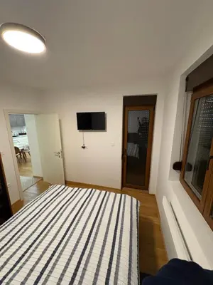 a bedroom with a bed and a flat screen tv at Maya 2 apartman sa dve spavace sobe in Vrnjačka Banja