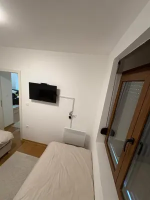 a bedroom with a bed and a tv on the wall at Maya 2 apartman sa dve spavace sobe in Vrnjačka Banja