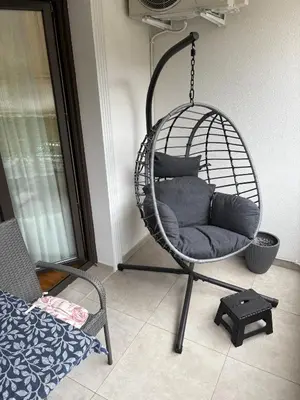 a hanging chair with pillows in a room at Maya 2 apartman sa dve spavace sobe in Vrnjačka Banja