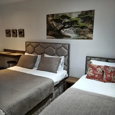a bedroom with two beds and a painting on the wall at Apartman Nik Brzeće Kopaonik in Brzeće
