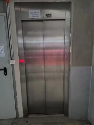 a metal elevator door with a sign on it at Apartman Nik Brzeće Kopaonik in Brzeće