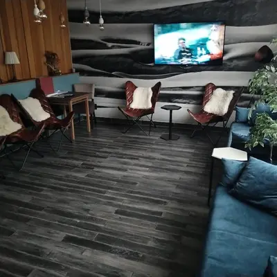 a living room with chairs and a flat screen tv at Apartman Nik Brzeće Kopaonik in Brzeće