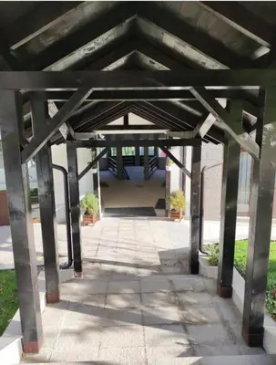 a large wooden structure with two potted plants under it at Apartman Nik Brzeće Kopaonik in Brzeće