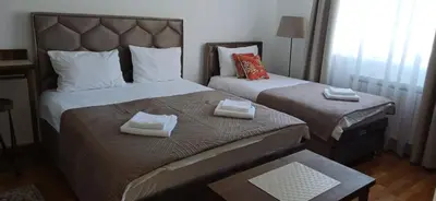 two beds in a hotel room with towels on them at Apartman Nik Brzeće Kopaonik in Brzeće