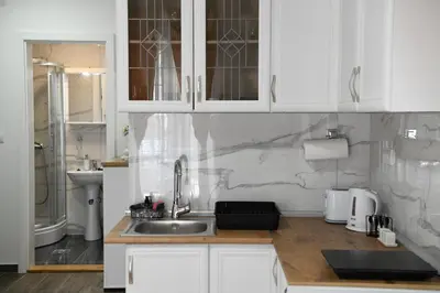 a kitchen with white cabinets and a sink at Apartman K2 in Vrnjačka Banja