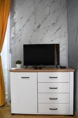 a white cabinet with a television on top of it at Apartman K2 in Vrnjačka Banja