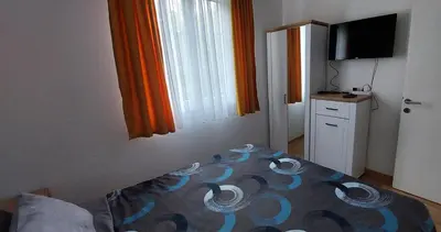 a small bedroom with a bed and a television at Apartman K2 in Vrnjačka Banja
