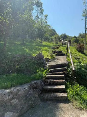 a set of stone steps on a grassy hill at Šumski mir in Despotovac