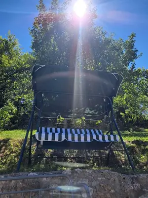 a park bench with the sun shining behind it at Šumski mir in Despotovac